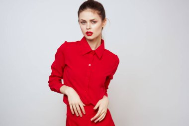 Açık arkaplanda kırmızı dudaklı bir kadının portresi. Makyaj modeli.