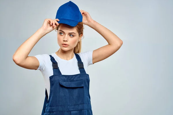Frau in Arbeitsuniform blau Mütze Service Lieferservice Licht Hintergrund — Stockfoto