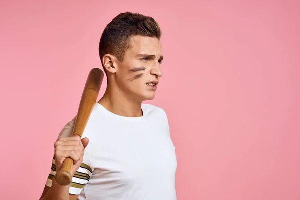 一个精力充沛的男人，戴着粉红背景的球棒，T恤脸蛋化作黑线攻击型 — 图库照片