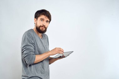 Elinde tablet, elinde internet teknolojisi olan bir adam. İletişim teknolojisi. Gri ceketli.