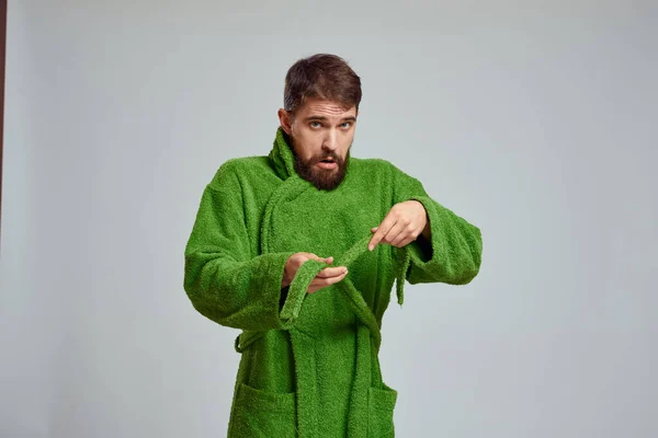 Vista de cerca de un hombre barbudo con una túnica verde sobre un fondo claro vista recortada — Foto de Stock