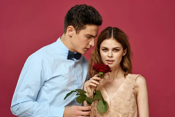 Portrét romantického páru v lásce s červenou růží na izolovaném pozadí a klasické oblek večerní šaty — Stock fotografie