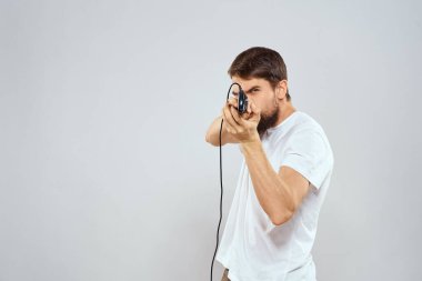 Elinde joystick 'i olan bir adam eğlenceli oyunlar oynuyor beyaz tişörtlü arka plan