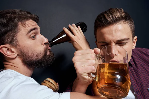 Dwóch pijanych przyjaciół pijących piwo odpoczywa w ciemnym tle — Zdjęcie stockowe