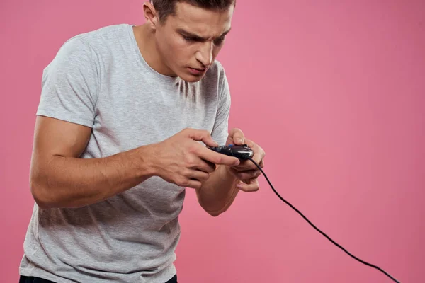 Vrolijke man met joystick draad technologie entertainment lifestyle roze achtergrond — Stockfoto