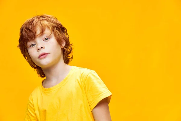 Portrait of a red-haired boy bent over to the side on an isolated background — Stock Photo, Image