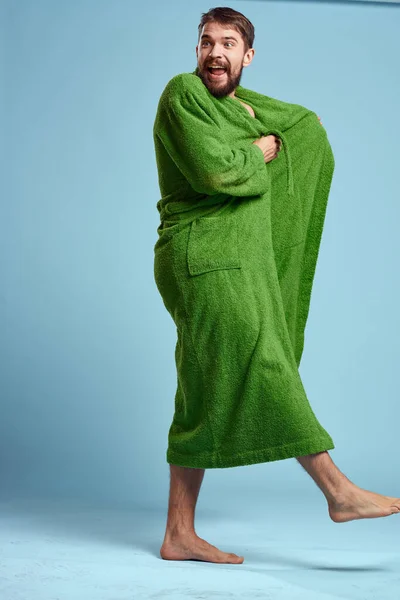 穿着绿色长袍,光着脚在蓝色背景下长大成人的男人 — 图库照片