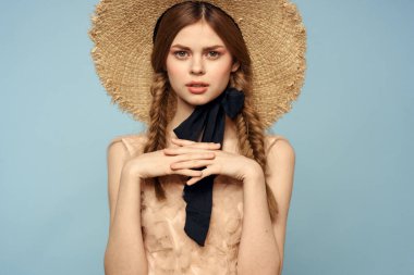 Gri arka planda hasır şapkalı romantik bir kız ve bej renkli bir elbise siyah kurdele duygu modeli.