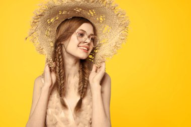 Sarı arka planda saman şapkalı portre kadın. Yazlık elbise mankeni romantizmi.