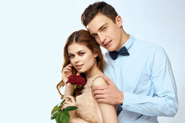 Young couple romance hug relationship dating red rose light studio background