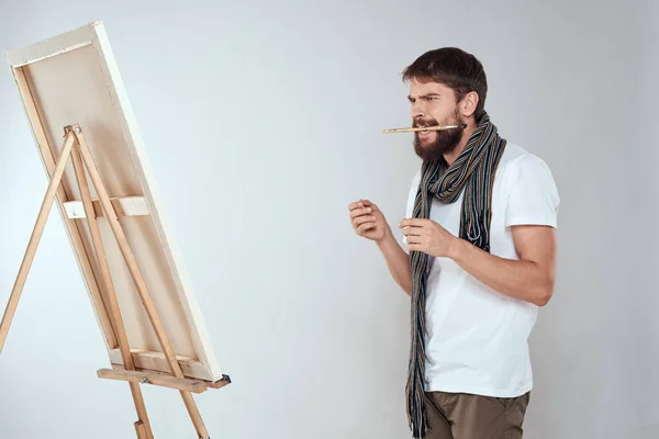 Мужчина художник рисует на мольберте шарф белой футболки художественное хобби творчество — стоковое фото