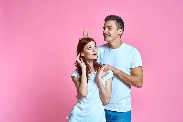 Amantes homem e mulher em jeans e t-shirt sobre rosa fundo recortado vista família romance adolescentes — Fotografia de Stock