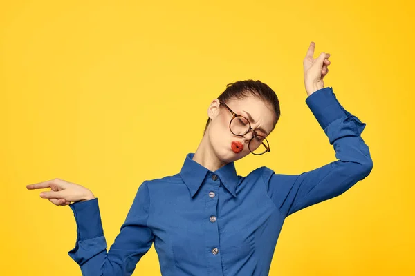 Vrouw met bril en blauw shirt gebaren met haar handen op gele achtergrond bijgesneden uitzicht Copy Space — Stockfoto