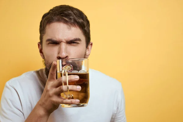 Sarı arka planda bir kupa birası olan beyaz tişört duyguları olan bir adam Boşluğu Kopyala — Stok fotoğraf