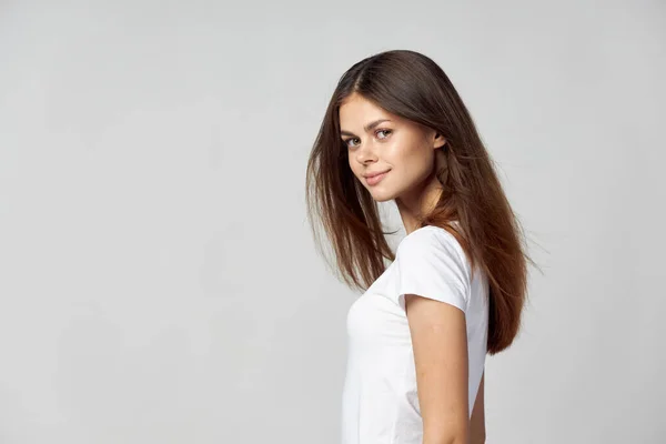 Menina agradável com cabelos longos em uma vista lateral branca camiseta — Fotografia de Stock