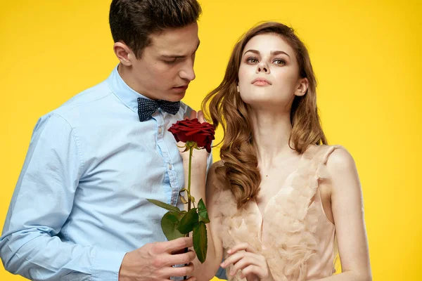 Enamored man and woman with red rose on yellow background cropped view close-up romance — Stock Photo, Image