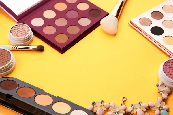 Professionelle Lidschatten und Make-up-Pinsel auf gelbem Hintergrund — Stockfoto