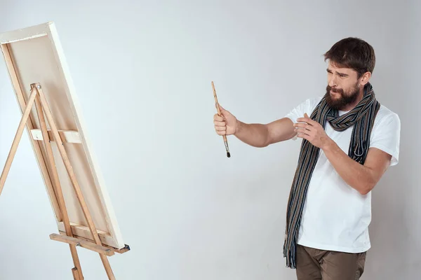 Ein Mann Künstler zeichnet auf einer Staffelei einen Schal weißes T-Shirt Kunst Hobby Kreativität — Stockfoto