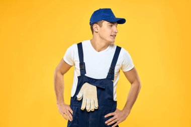 Çalışan üniformalı adam duygularını servis hizmeti sarı arka planda sunuyor