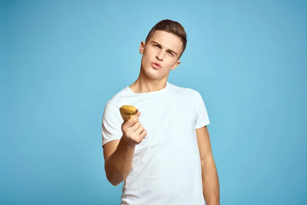 Happy man met vers fruit gebaren met handen blauwe achtergrond wit t-shirt vitaminen bananen — Stockfoto