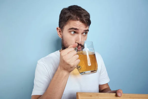 Hombre alegre taza de cerveza comida rápida dieta estilo de vida azul fondo alcohol — Foto de Stock