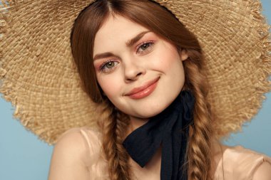 Hasır şapkalı kız portresi yakın çekim at kuyruğu eğlenceli kızıl saçlı mavi arka plan