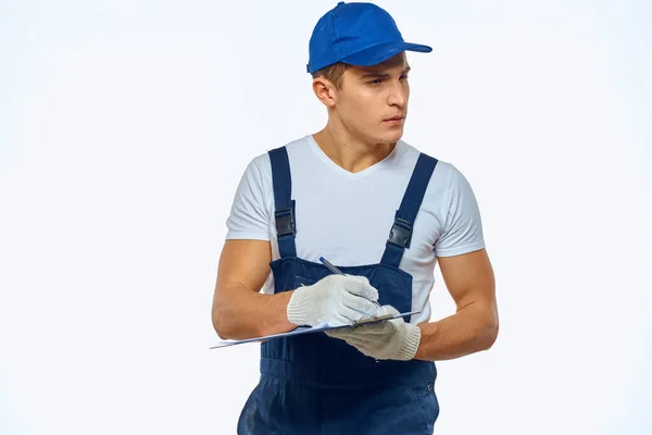 A man in a working uniform a delivery service loader light background — Stock Photo, Image