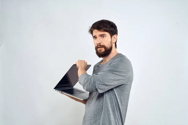 Bearded man with laptop in hands internet communication technology light background