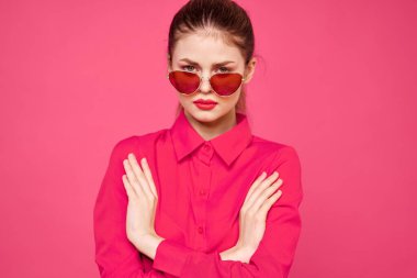 Pembe gömlekli ve kahverengi gözlüklü kadın kırpılmış görünüm modeli duyguları el hareketleriyle resim yapıyor.