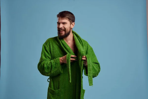 Бородатый мужчина в зеленом халате с поясом на синем фоне обрезанный вид эмоций — стоковое фото
