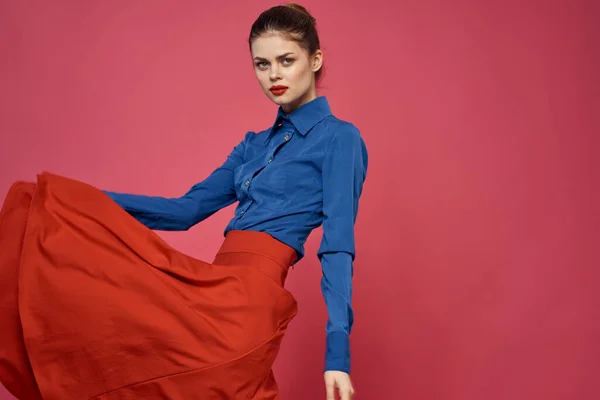 Mujer en camisa azul y cubos rojos sobre fondo rosa emociones divertidas modelo recortado ver — Foto de Stock