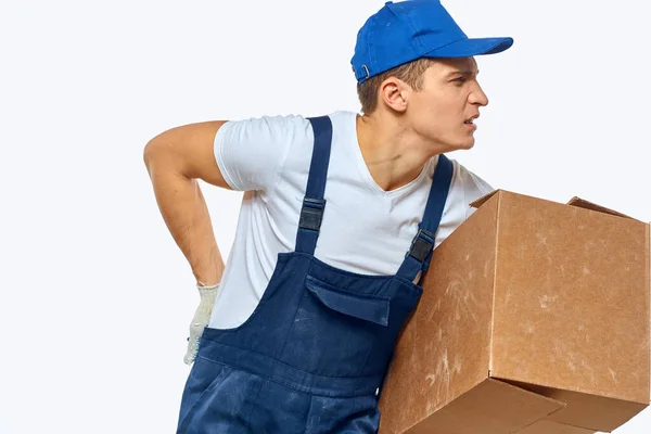 Muž pracovník s krabicí v ruce dodávka nakládka služby práce světlo pozadí — Stock fotografie