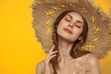 Şapkalı ve elbiseli bir bayan. Kızıl saçlı, sarı arka planlı, model portresi eğlenceli.