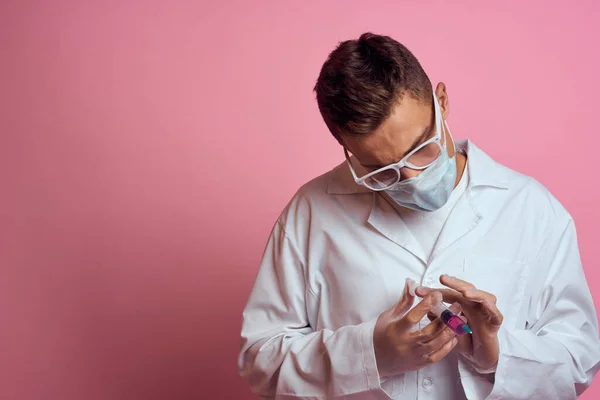 Tıbbi maskeli ve eldivenli bir doktor şırıngayı bir şırınga laboratuvarında tutuyor. — Stok fotoğraf