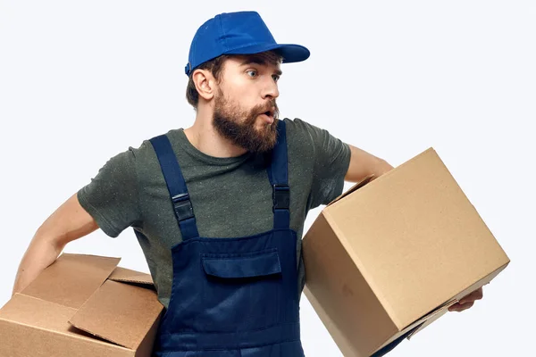 Мужчина в рабочей форме с коробкой в руках, доставляющий работу. — стоковое фото