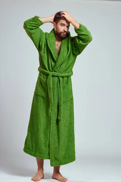 녹색 가운을 입고 밝은 배경에 밝은 배경에 있는 감정적 인 남자 전체 성장 재미있는 감정 모델 — 스톡 사진