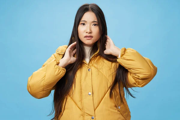 Asiatin mit dunklen Haaren in gelber Jacke vor isoliertem Hintergrund — Stockfoto