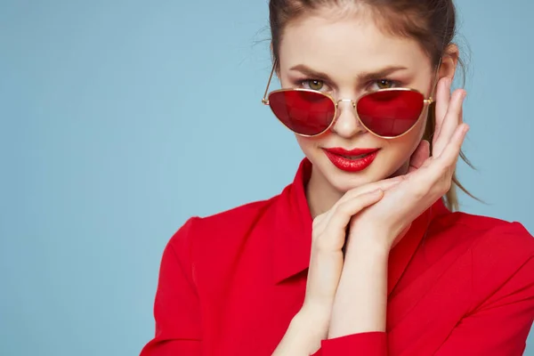 Beautiful woman in dark glasses red shirt bright makeup emotions attractive look blue background — Stock Photo, Image