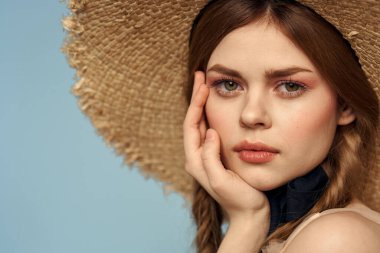 Hasır şapkalı kız portresi yakın çekim at kuyruğu eğlenceli kızıl saçlı mavi arka plan