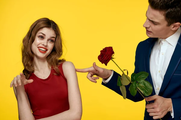 Fiatal bájos pár rózsa kapcsolat romantika ajándék, mint egy életmód sárga elszigetelt háttér — Stock Fotó