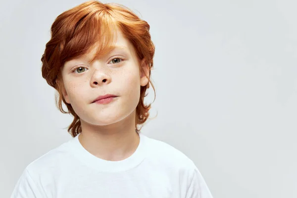 Carino dai capelli rossi ragazzo in un bianco t-shirt uovo primo piano copia spazio — Foto Stock