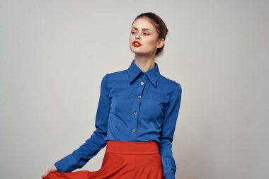 Mavi gömlekli zarif bir bayan, elleri arka planda ve yakın plan bir fotokopi portresiyle hareket ediyor.