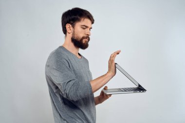 Dizüstü bilgisayarı olan duygusal bir adam. Modern tarz, hafif arka plan.