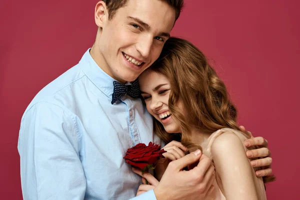 Lovers people with rose in hands on pink isolated background hug emotions happiness romance feelings