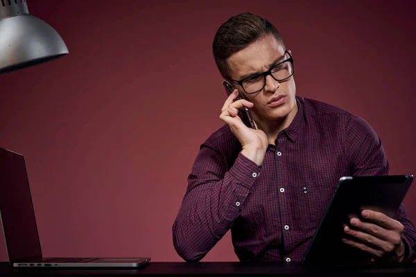 Homem de negócios no escritório e falando sobre o gerente de telefone modelo de fundo vermelho corte vista de tablet laptop — Fotografia de Stock