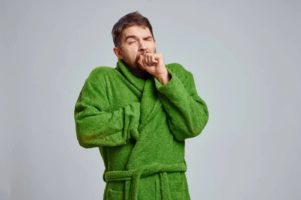 Vista de cerca de un hombre barbudo con una túnica verde sobre un fondo claro vista recortada —  Fotos de Stock