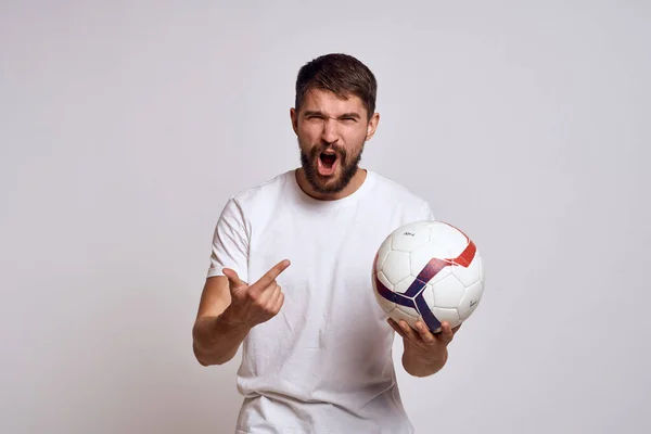 Чоловічий тренер з футбольним м'ячем в руках на світлому тлі енергетичного пояснення рухів — стокове фото