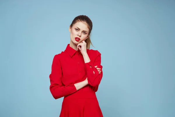 Atractiva mujer en ropa brillante sobre fondo azul gesto con las manos y los labios rojos maquillaje recortado ver emociones — Foto de Stock