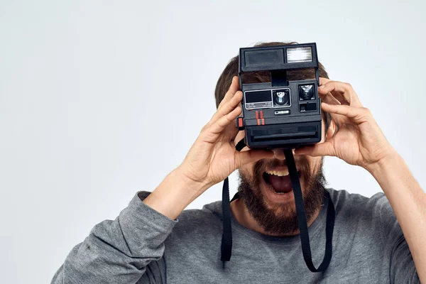 Чоловік-фотограф тримає професійну камеру лінза творча студія роботи світлого фону — стокове фото