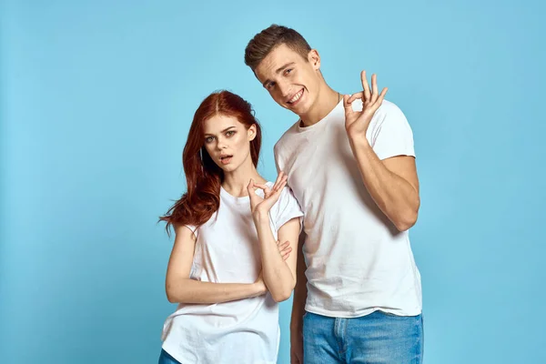 Емальований чоловік і жінка в джинсах і футболка на синьому фоні обіймають один одного і отримують задоволення — стокове фото